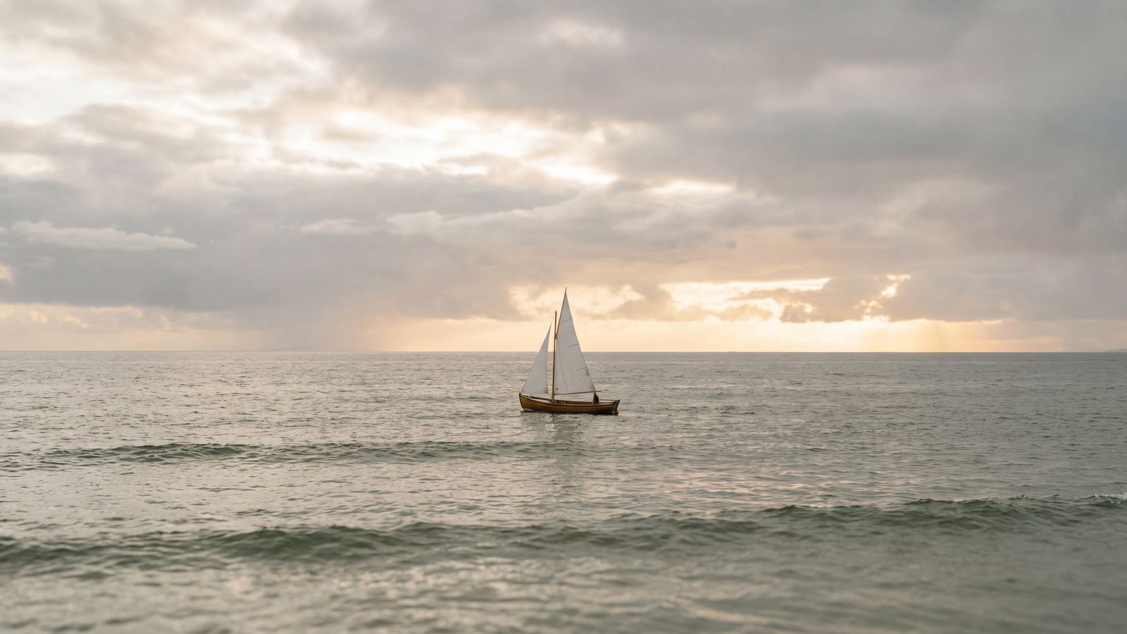 A small sailing boat on calm open sea after a storm