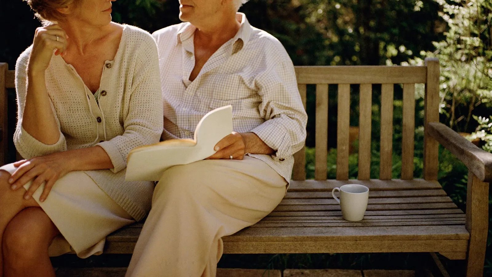 An older couple sitting together on a garden bench